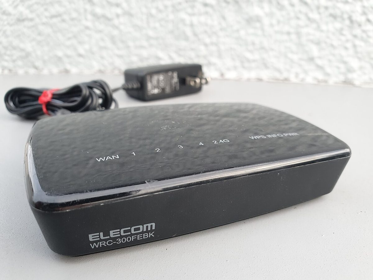 Router Wi-Fi negro con cable de corriente sobre una mesa